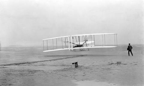 First successful flight of the Wright Flyer, by the Wright brothers (1903-12-17). Photo: John T. Daniels, Public domain.